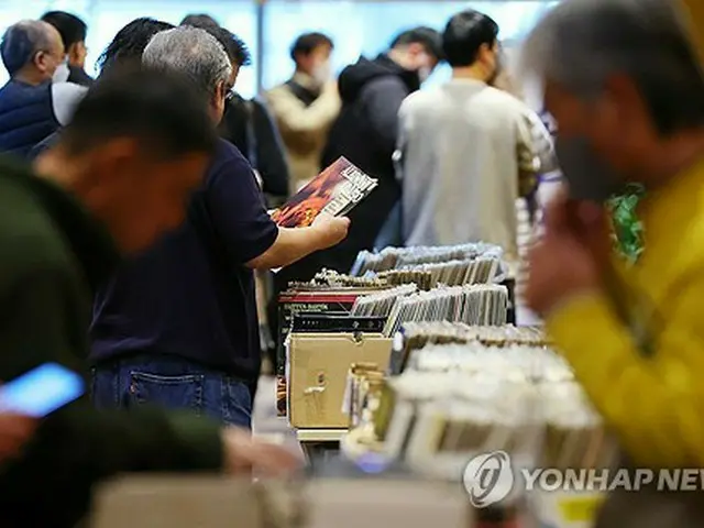 １２月上旬にソウルで開かれた「オーディオエキスポ２０２３」の会場でレコードを手に取る来場者（資料写真）＝（聯合ニュース）