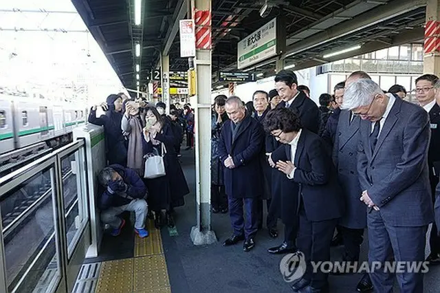 新大久保駅ホームで手を合わせる辛潤賛さん（手前右から２人目）＝２６日、東京（聯合ニュース）