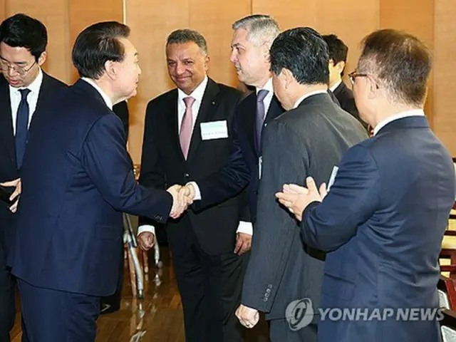 外資系企業の代表らとあいさつを交わす尹大統領（左、大統領室通信写真記者団）＝１４日、ソウル（聯合ニュース）