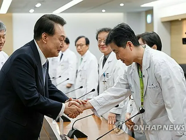 懇談会に参加した医療スタッフと握手を交わす尹大統領（左、大統領室提供）＝（聯合ニュース）≪転載・転用禁止≫