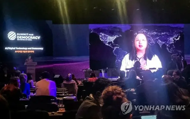 民主主義サミット初日の１８日に会場で流された台湾の唐鳳（オードリー・タン）デジタル発展相のビデオメッセージ＝（聯合ニュース）