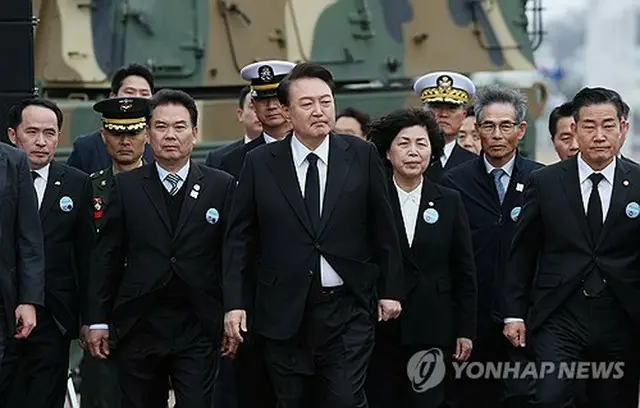 「西海守護の日」記念式典の会場に入る尹大統領（中央）と、遺族や将兵の代表＝２２日、平沢（聯合ニュース）