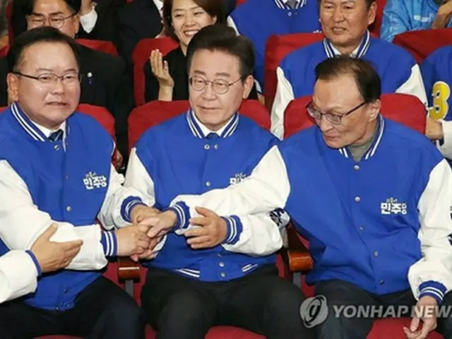 開票速報をみながら握手を交わす共に民主党執行部（共同取材）＝１０日、ソウル（聯合ニュース）