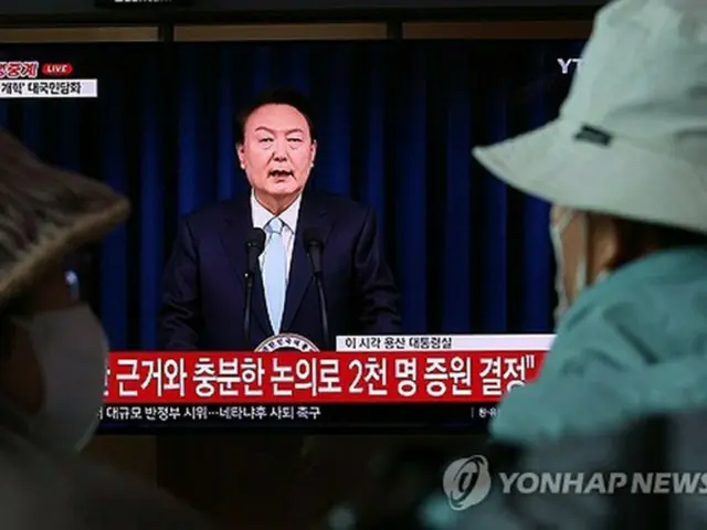 大学医学部の定員増を巡る尹大統領の国民向け談話をテレビで見る市民＝１日、ソウル（聯合ニュース）