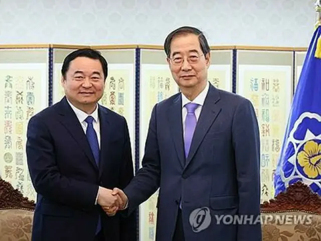 政府ソウル庁舎で握手を交わす韓国の韓悳洙首相（右）と中国の郝鵬・遼寧省共産党委員会書記（首相室提供）＝（聯合ニュース）≪転載・転用禁止≫