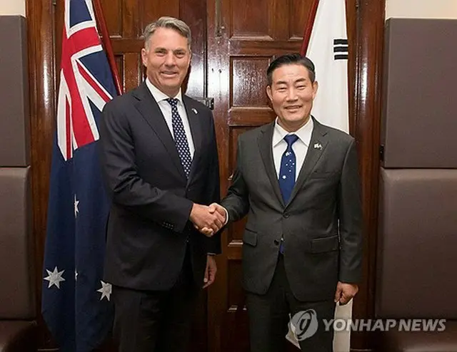 握手する申長官（右）とマールズ副首相兼国防相（国防部提供）＝（聯合ニュース）≪転載・転用禁止≫