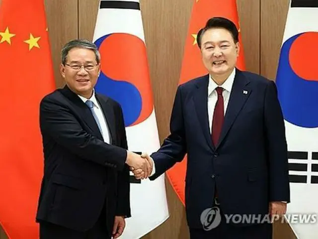 会談で握手を交わす韓国の尹錫悦大統領（右）と中国の李強首相（大統領室通信写真記者団）＝２６日、ソウル（聯合ニュース）