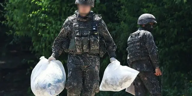 ２９日、ソウル南方の京畿道平沢市内の山で、風船が飛ばしてきた物体を回収する軍将兵＝（聯合ニュース）