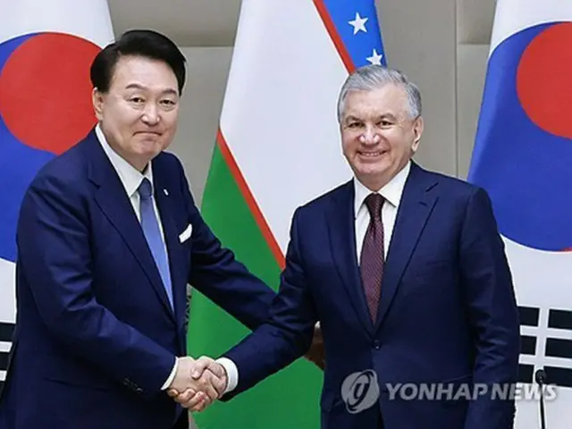 握手を交わす尹大統領(左)とミルジヨエフ大統領=14日、タシケント(聯合ニュース)