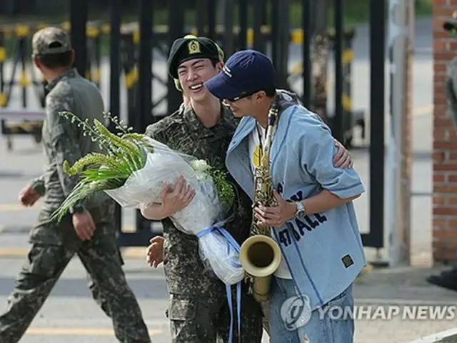 除隊したＪＩＮと笑顔であいさつを交わすＲＭ＝（聯合ニュース）