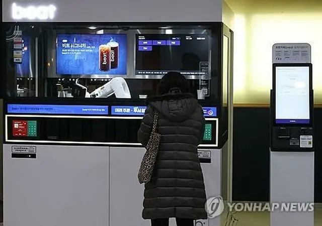 デジタル機器で飲み物を注文する女性（資料写真）＝（聯合ニュース）
