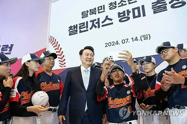 脱北者の青少年でつくる野球チーム「チャレンジャーズ」の選手たちと記念撮影する尹大統領（大統領室提供）＝１４日、ソウル（聯合ニュース）≪転載・転用禁止≫