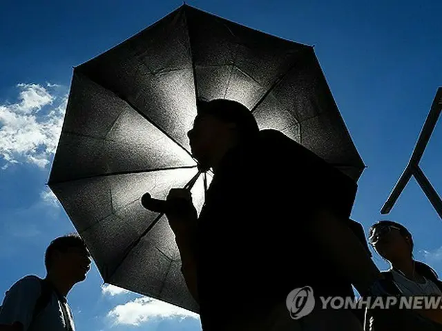 韓国南東部、大邱で日傘を差して歩く市民＝（聯合ニュース）