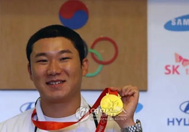 金メダルを掲げるチン・ジョンオ＝12日、北京（聯合）