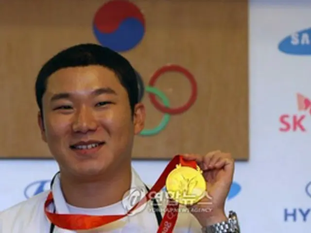 金メダルを掲げるチン・ジョンオ＝12日、北京（聯合）