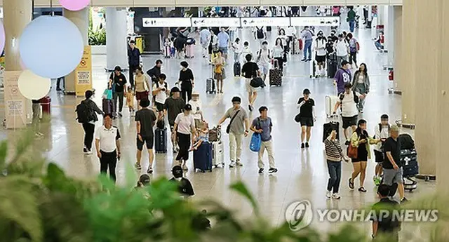 帰省客や旅行客で混雑する済州国際空港の到着ロビー＝１３日、済州（聯合ニュース）