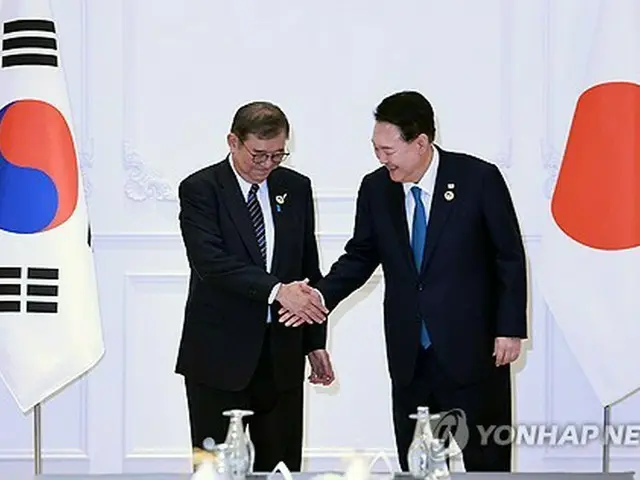 首脳会談で握手を交わす韓国の尹大統領（右）と日本の石破首相＝１０日、エンチャン（聯合ニュース）