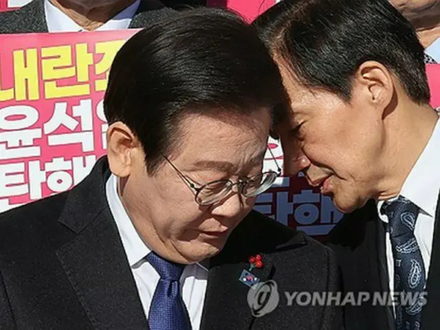 共に民主党を含む野党５党と市民団体が国会議事堂前で行った共同記者会見で、野党「祖国革新党」の曺国（チョ・グク）代表（右）と会話する李在明氏＝６日、ソウル（聯合ニュース）