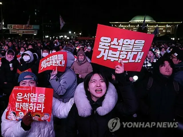 尹大統領の弾劾を求めて国会周辺に集まった市民がシュプレヒコールを叫んでいる＝７日、ソウル（聯合ニュース）