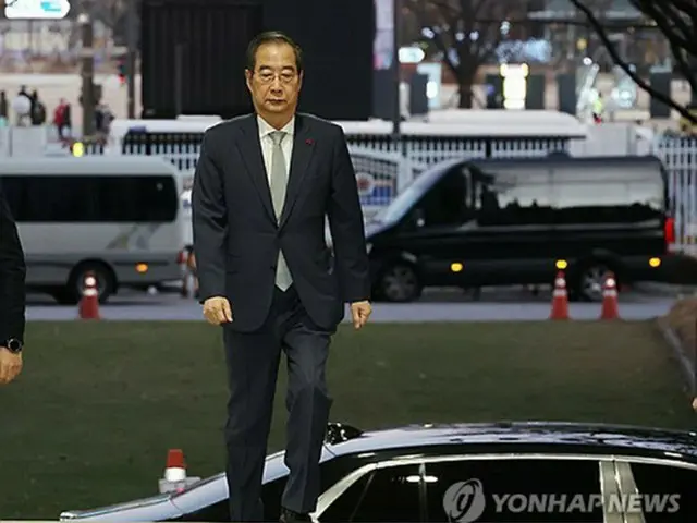 尹大統領に対する弾劾可決後、政府ソウル庁舎に入る韓首相＝１４日、ソウル（聯合ニュース）