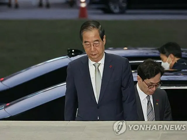 弾劾案の可決後に政府ソウル庁舎に入る韓首相＝１４日、ソウル（聯合ニュース）