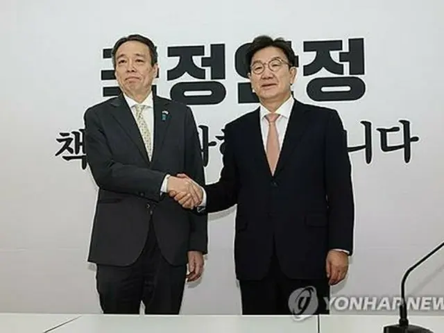 国会で面会し、握手を交わす「国民の力」の権性東院内代表（右）と日本の水嶋光一駐韓大使＝２６日、ソウル（聯合ニュース）