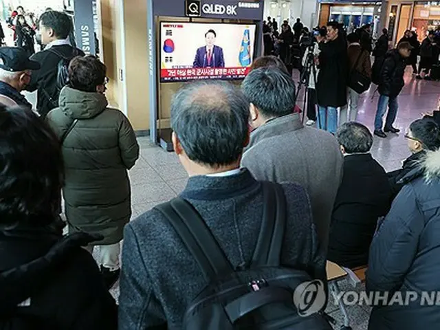 ソウル駅に設置されたテレビで尹大統領の国民向け談話の発表を見守る市民ら（資料写真）＝（聯合ニュース）