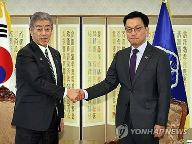 握手を交わす崔相穆大統領代行（右）と岩屋毅氏＝１４日、ソウル（聯合ニュース）