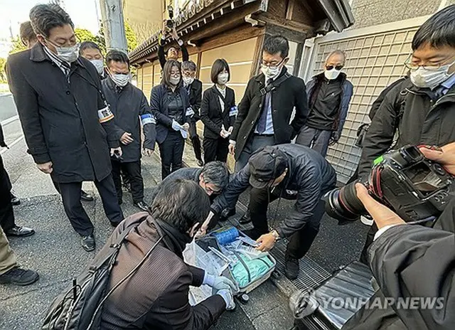 戦後拉北者被害家族連合会が持参した荷物を確認する警備当局の関係者＝３０日、東京（聯合ニュース）