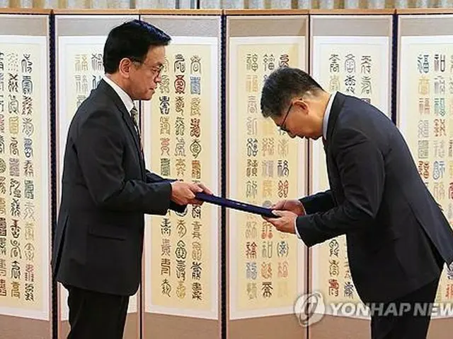 初代キューバ大使に任命された李昊烈（イ・ホヨル）氏（右）に任命状を授与する崔氏＝３１日、ソウル（聯合ニュース）