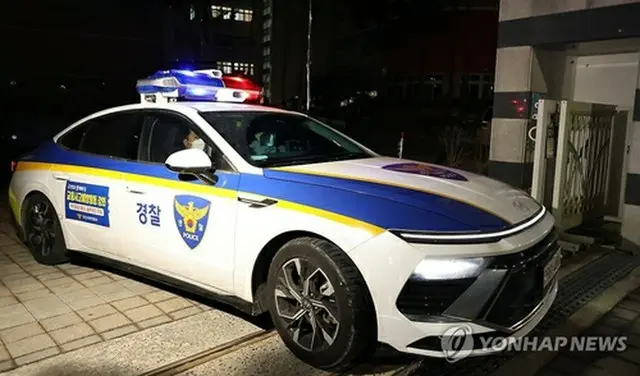 事件があった小学校を出るパトカー＝１０日、大田（聯合ニュース）