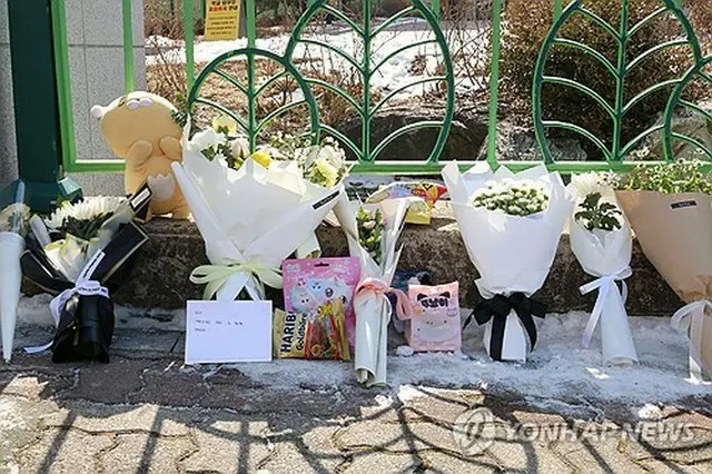 事件現場の小学校前に手向けられた花やお菓子＝１１日、大田（聯合ニュース）