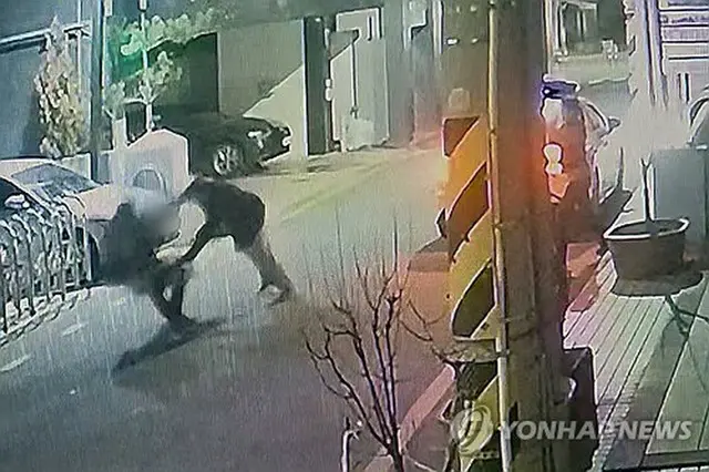 刃物を持った男に襲われる警察官（読者提供）＝（聯合ニュース）≪転載・転用禁止≫