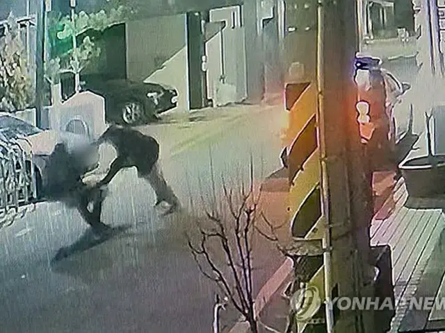 刃物を持った男に襲われる警察官（読者提供）＝（聯合ニュース）≪転載・転用禁止≫