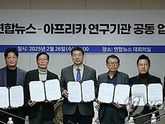 協約書を手に記念撮影する聯合ニュースの黄大一社長（中央）と８機関の代表＝２６日、ソウル（聯合ニュース）