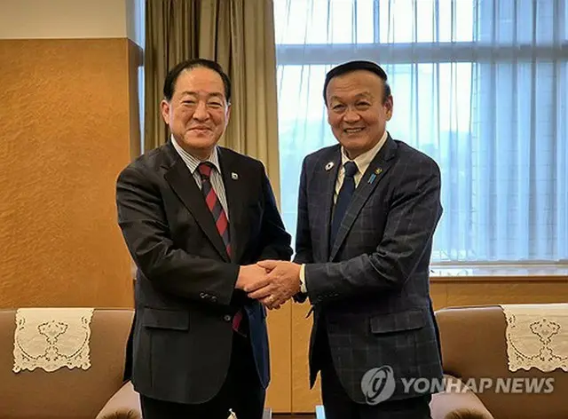握手を交わす李秉宣市長（左）と藤井裕久市長＝７日、富山（聯合ニュース）
