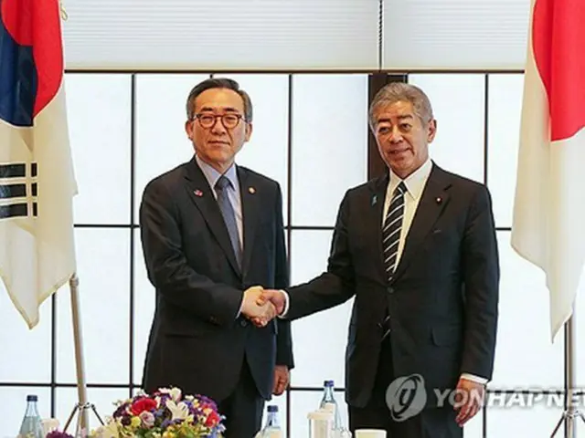 握手を交わす韓日外相＝２２日、東京（聯合ニュース）