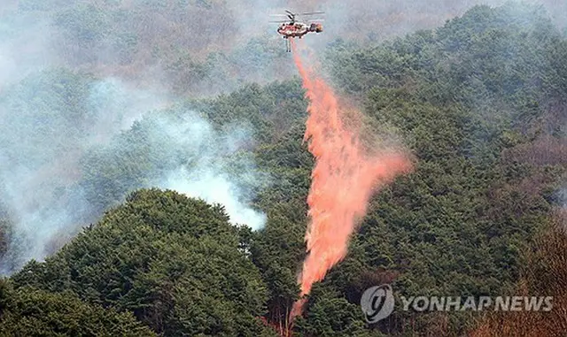 消火作業を行うヘリコプター＝２５日、山清（聯合ニュース）