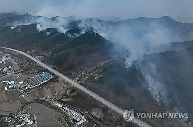 慶尚北道安東市で２７日、高速道路に沿って山から煙が上がっている＝（聯合ニュース）