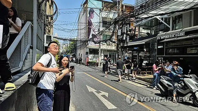 タイの街なかで地震の揺れに驚く観光客ら＝２８日、聯合ニュース