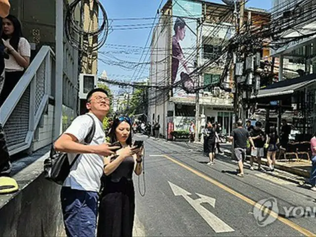 タイの街なかで地震の揺れに驚く観光客ら＝２８日、聯合ニュース