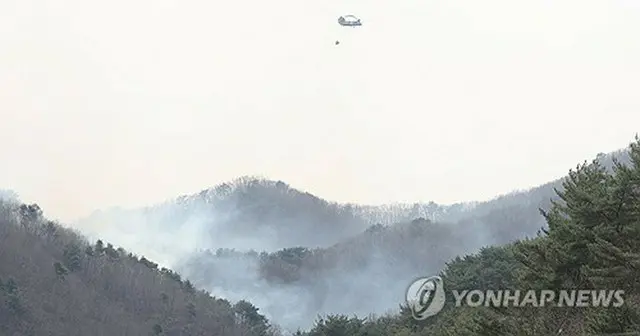 消火作業に当たる在韓米軍のヘリコプター＝２８日、山清（聯合ニュース）