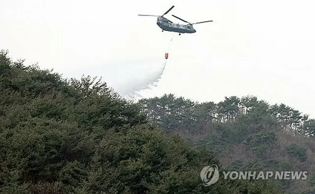 山林に水をまくヘリコプター「ＣＨ４７」＝２８日、山清（聯合ニュース）