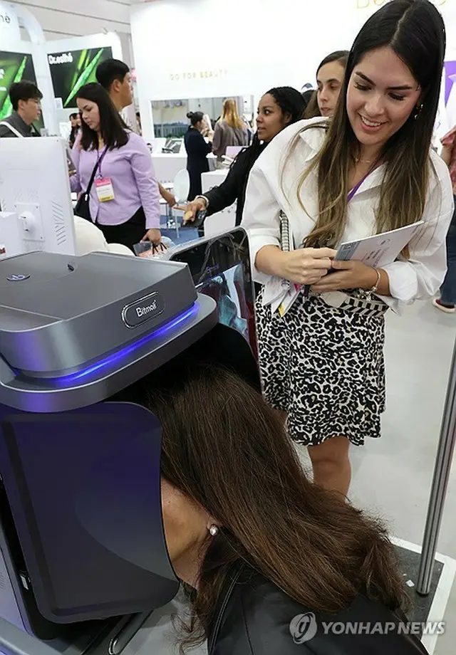 ソウルで昨年開かれたソウル国際化粧品美容健康産業博覧会で美容器具を体験する外国人（資料写真）＝（聯合ニュース）