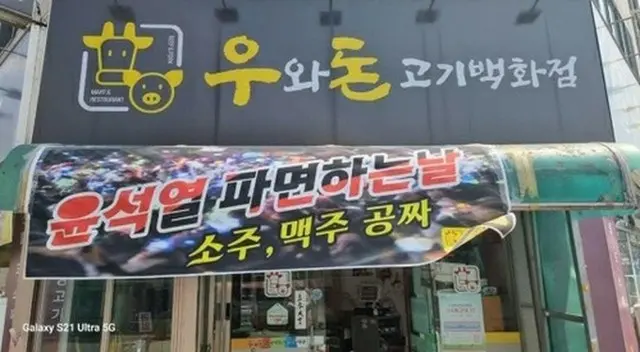 焼酎とビールを無料にするという横断幕を掲げた飲食店（読者提供）＝（聯合ニュース）≪転載・転用禁止≫