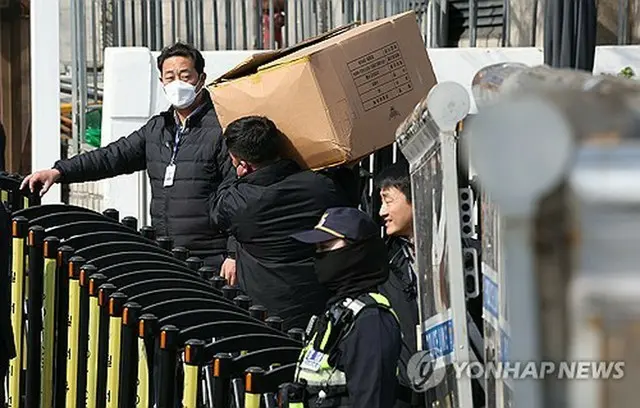 ソウル・漢南洞の大統領公邸前で警察関係者が装備を運んでいる＝４日、ソウル（聯合ニュース）