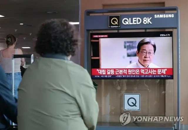 ソウル駅で「共に民主党」の李在明代表の出馬宣言映像を見る市民＝１０日、ソウル（聯合ニュース）