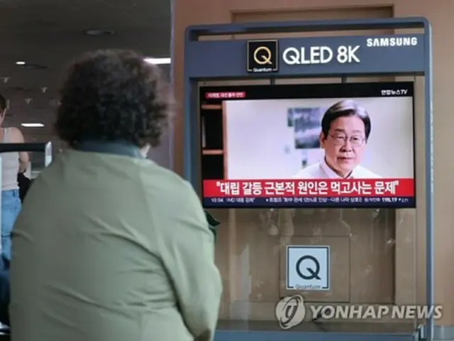 ソウル駅で「共に民主党」の李在明代表の出馬宣言映像を見る市民＝１０日、ソウル（聯合ニュース）