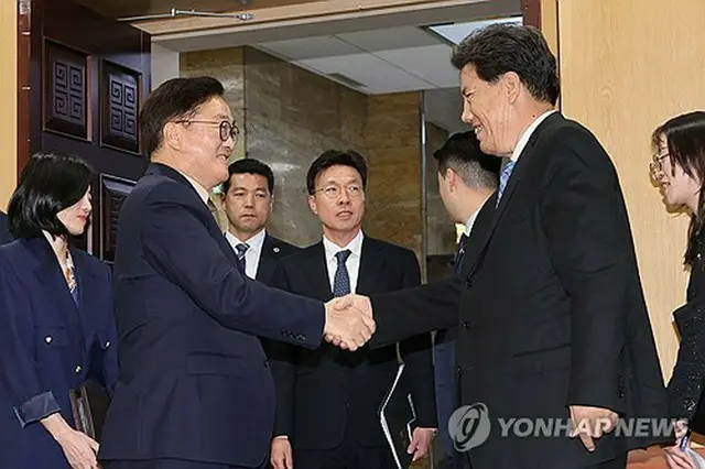 握手を交わす禹氏（左）とロサン・ギェンツェン氏＝１０日、ソウル（聯合ニュース）