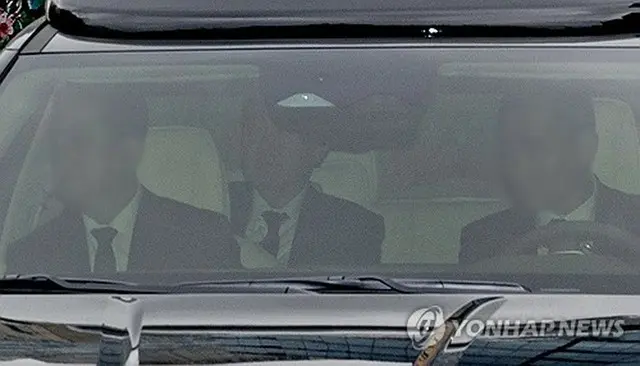 車に乗ってソウル中央地裁に入る尹氏（後ろ）＝１４日、ソウル（聯合ニュース）